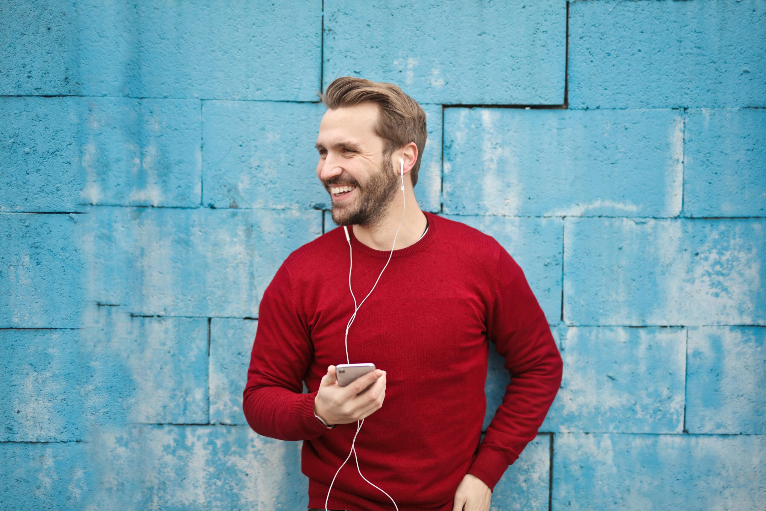Man with red sweater portrait against brick blue wall